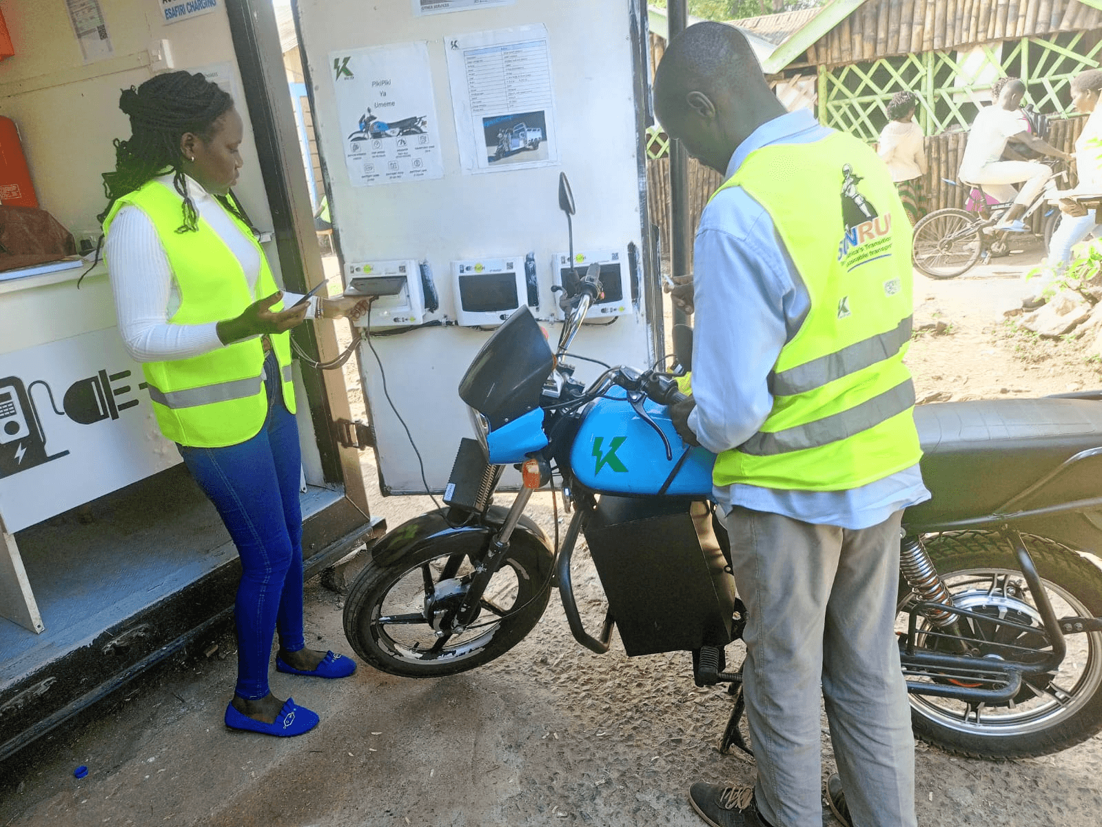 A rider charging their bike at the Dunga Beach Hub
